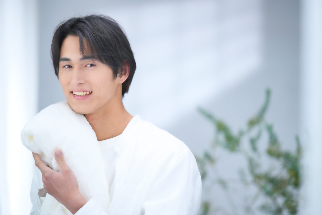 タオルに顔を当てる男性