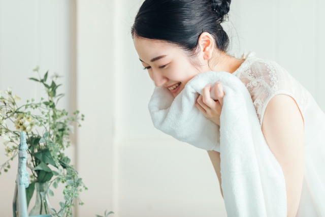 首下にタオルを当てる女性
