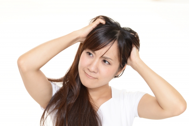 髪の毛を掻き毟る女性