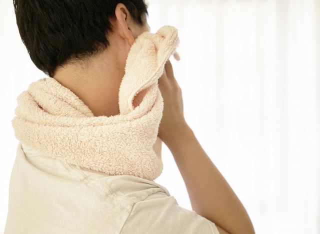 タオルで顔を拭く男性