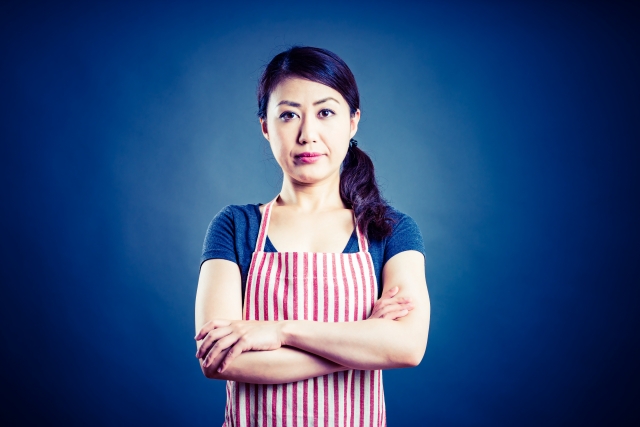 ブルーバックで腕を組む女性